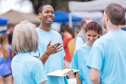 Volunteer leader giving instructions at outdoor festival or market